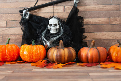 High angle view of skull and pumpkins on table during halloween