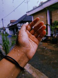 Cropped image of woman hand on wet rainy season