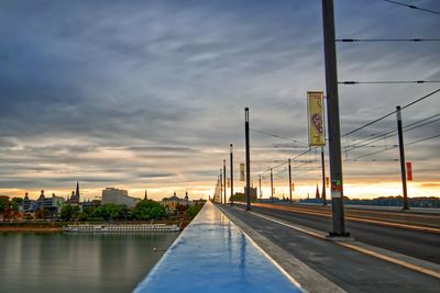 Bridge over road against sky at sunset