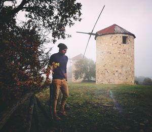 Full length of man standing by tree against sky