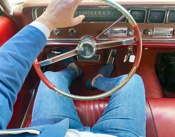 Midsection of man holding camera while sitting in car