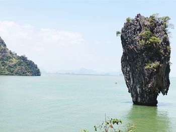 Rock formation in sea against sky