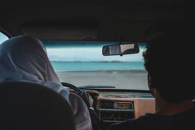 Rear view of man driving car