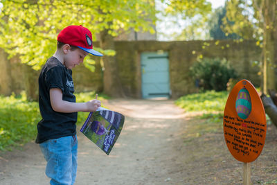 Side view of boy holding hat