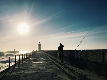 Full length of woman standing on footpath against lighthouse