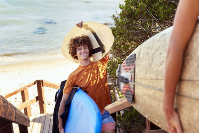 Couple carrying surfboards leaving the beach