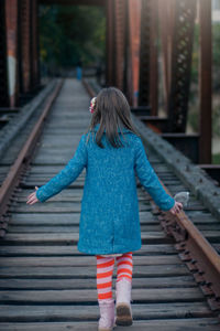 Full length of young woman standing on railing