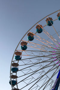 Low angle view of ferris wheel against clear blue sky