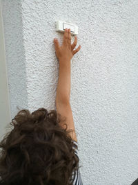 Rear view boy ringing doorbell