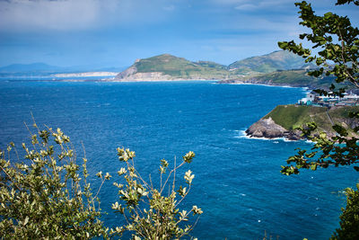 Scenic view of sea and mountains against sky