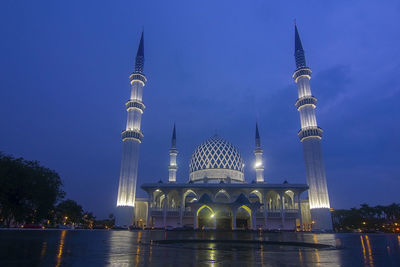 Illuminated fountain of building against sky