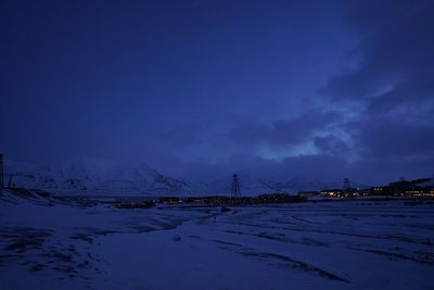 Scenic view of snow covered field against sky at night