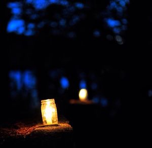 Close-up of lit candle in dark room