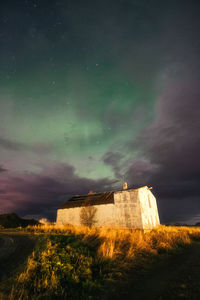Faint northern lights over abandoned building at night