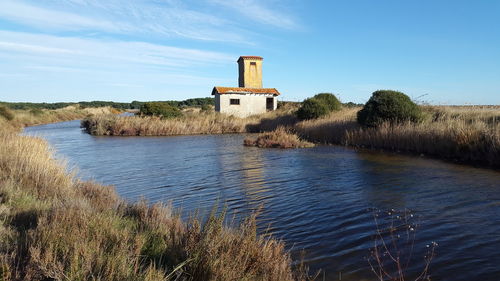 Scenic view of lake by building against sky