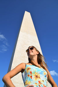 Low angle view of woman against blue sky