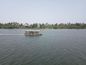 Boat sailing in river against clear sky