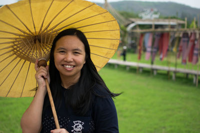 Portrait of a smiling young woman holding umbrella