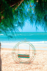 Deck chairs on beach against sky