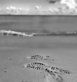 Surface level of text on beach against sky