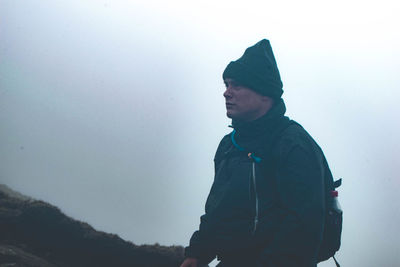 Man hiking against sky during winter