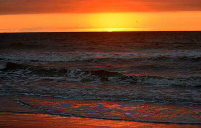 Scenic view of sea against orange sky