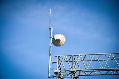 Low angle view of communications tower against blue sky