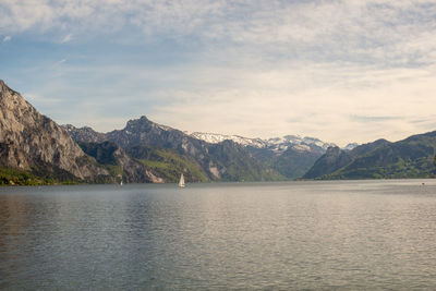 Scenic view of lake by mountains against sky