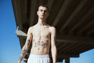 Portrait of young man standing against wall