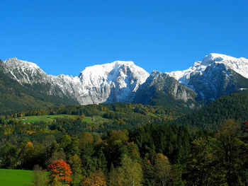 Scenic view of snowcapped mountains against clear blue sky