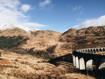 Glenfinnan viaduct by mountains against sky