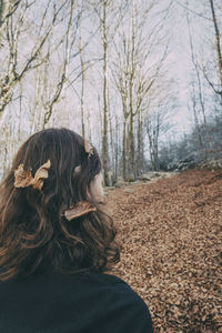 Woman enjoying autumn and catching falling yellow leaves