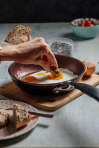Midsection of person having breakfast on table