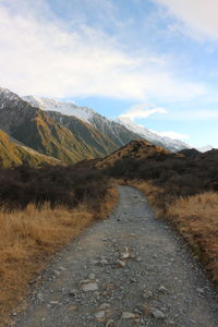 Road leading towards mountain against sky