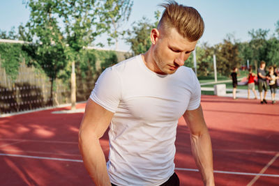 Side view of young man exercising in gym