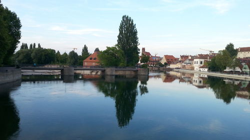 Scenic view of lake by buildings against sky