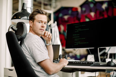 Portrait of male computer programmer sitting in office