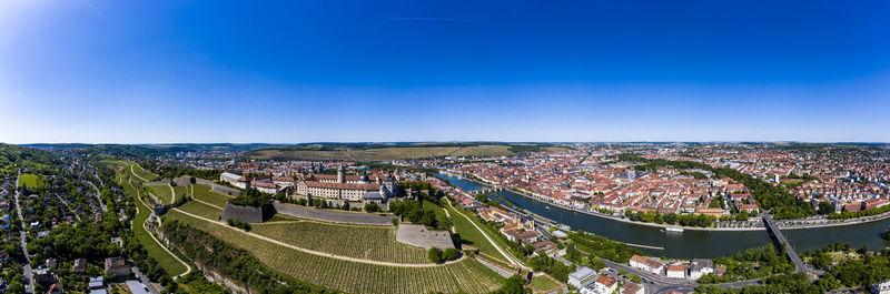 High angle view of city buildings against blue sky