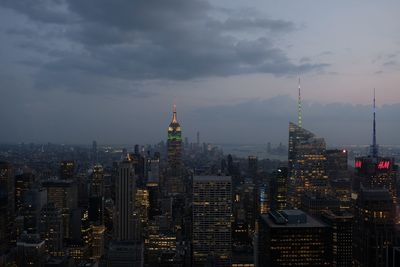 Modern buildings in city against cloudy sky