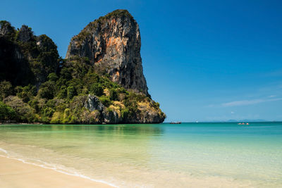 Railay west beach with limestone mountain, crystal green sea, and blue sky in krabi, thailand. 