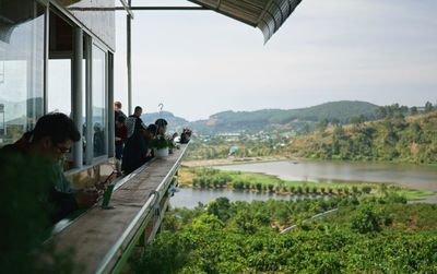 Rear view of people on lake against sky