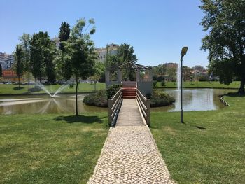 Footpath in park against clear sky