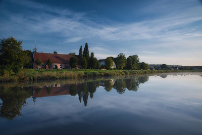 Scenic view of lake by buildings against sky