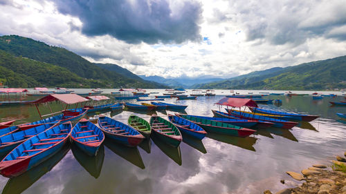 Panoramic view of boats moored in lake against sky