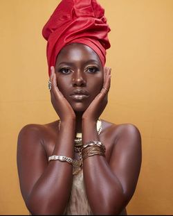 Portrait of a culture wearing young woman against yellow background