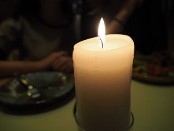 Close-up of illuminated candles on table