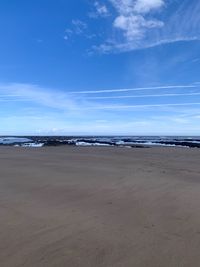 Scenic view of beach against blue sky