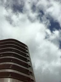 Low angle view of modern building against cloudy sky