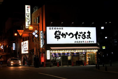 Road sign on street in city at night