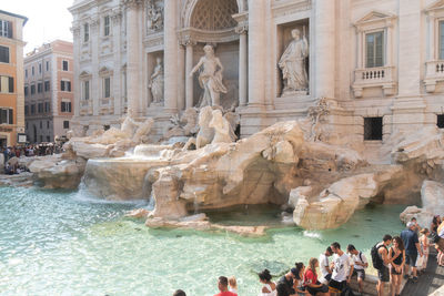 Tourists at trevi fountain, in the centre of rome designed by architect nicola salvi